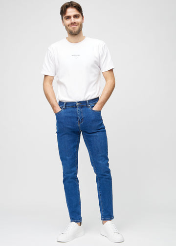 Full-length view of a model in dark blue denim slim jeans.