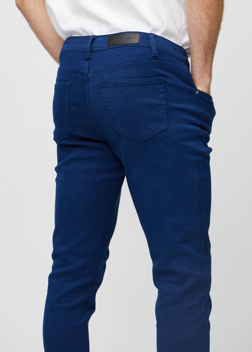 Close-up back view of dark blue slim jeans showing details.