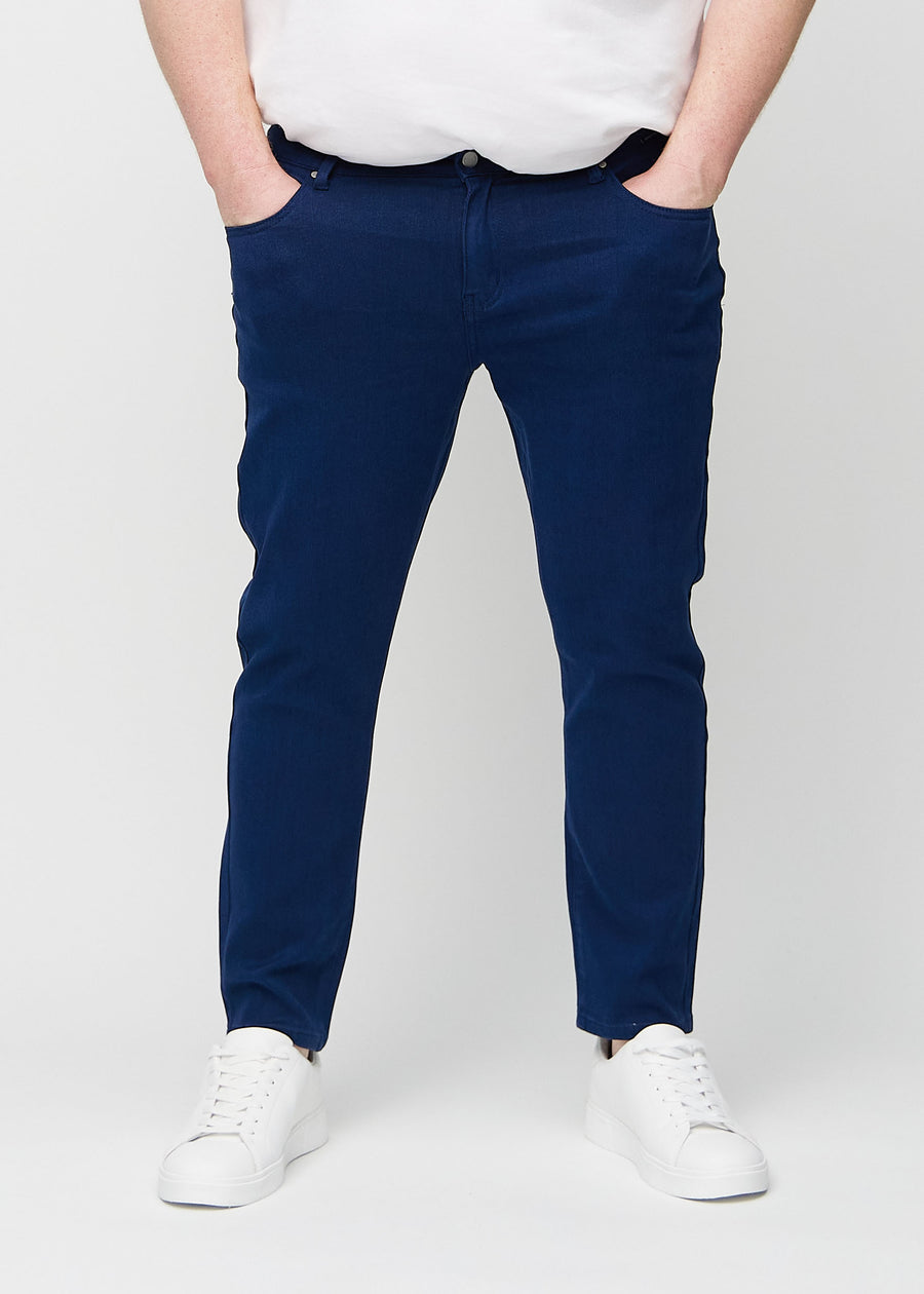 Dark blue slim jeans, model name Royals, fitted closely along the legs on a plus-size model, front view.