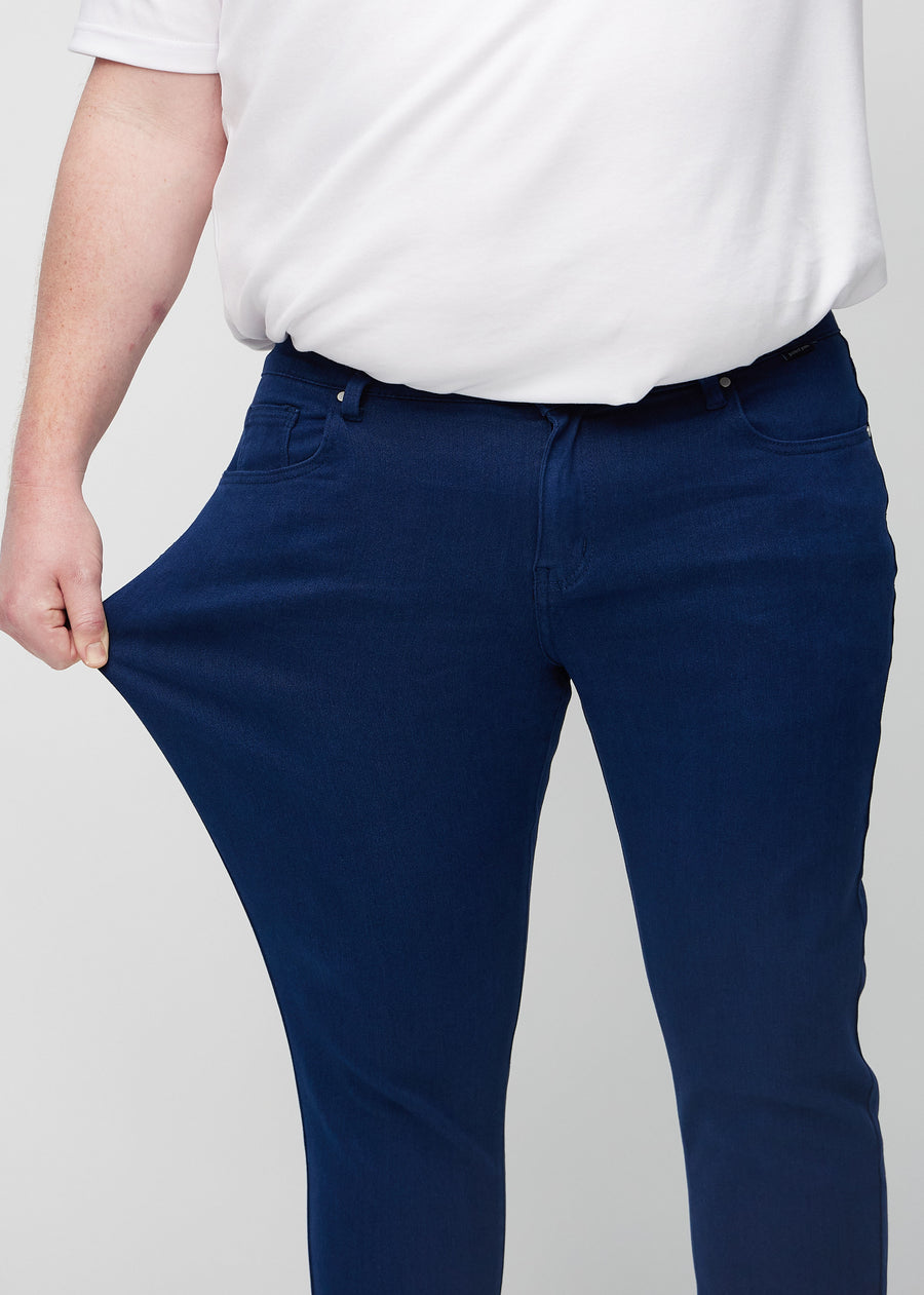 Plus-size model stretches the jeans at the thigh to show the fabric&