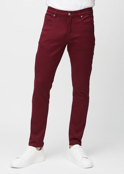 Dark red slim jeans, model name Santas, fitted closely along the legs, front view.