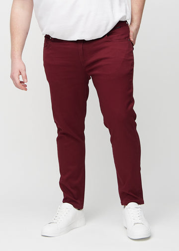 Dark red slim jeans, model name Santas, fitted closely along the legs on a plus-size model, front view.