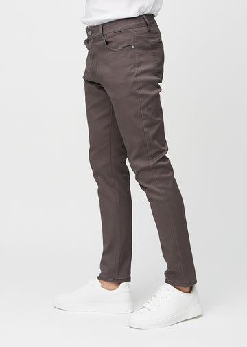 Grey-brown slim jeans viewed from the side on a model.