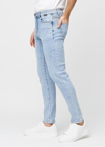 Light blue denim slim jeans viewed from the side on a model.
