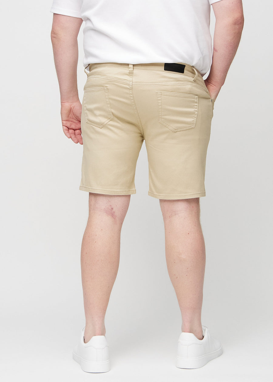 Beige middle-slim shorts seen from the back on a plus-size model, so the entire product can be seen.