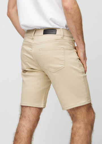 Beige middle-slim shorts seen from the back up close to show details.
