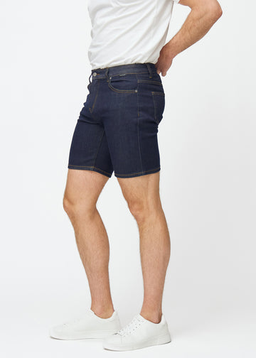 Deep dark blue denim shorts for men in the colour Midnights with a slim fit seen from the side on a model.