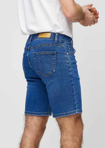 Dark denim middle-slim shorts seen from the back close up to show details.