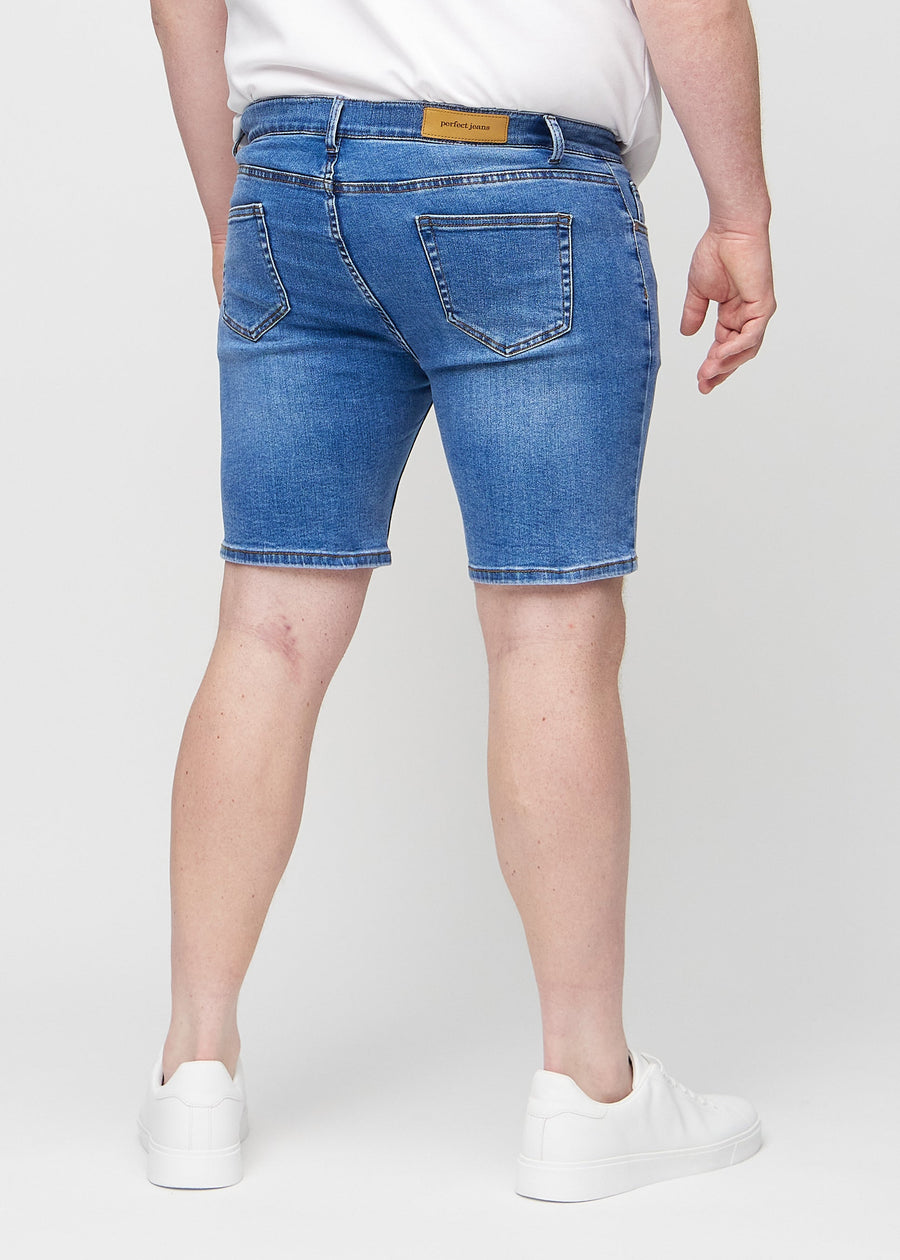 Denim middle-slim shorts seen from the back on a plus-size model, so the entire product can be seen.
