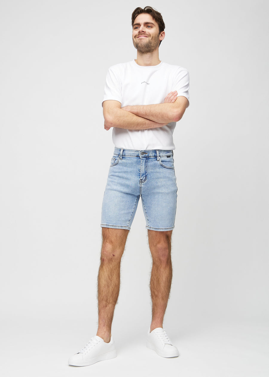 Full image of model in light denim middle-slim shorts.