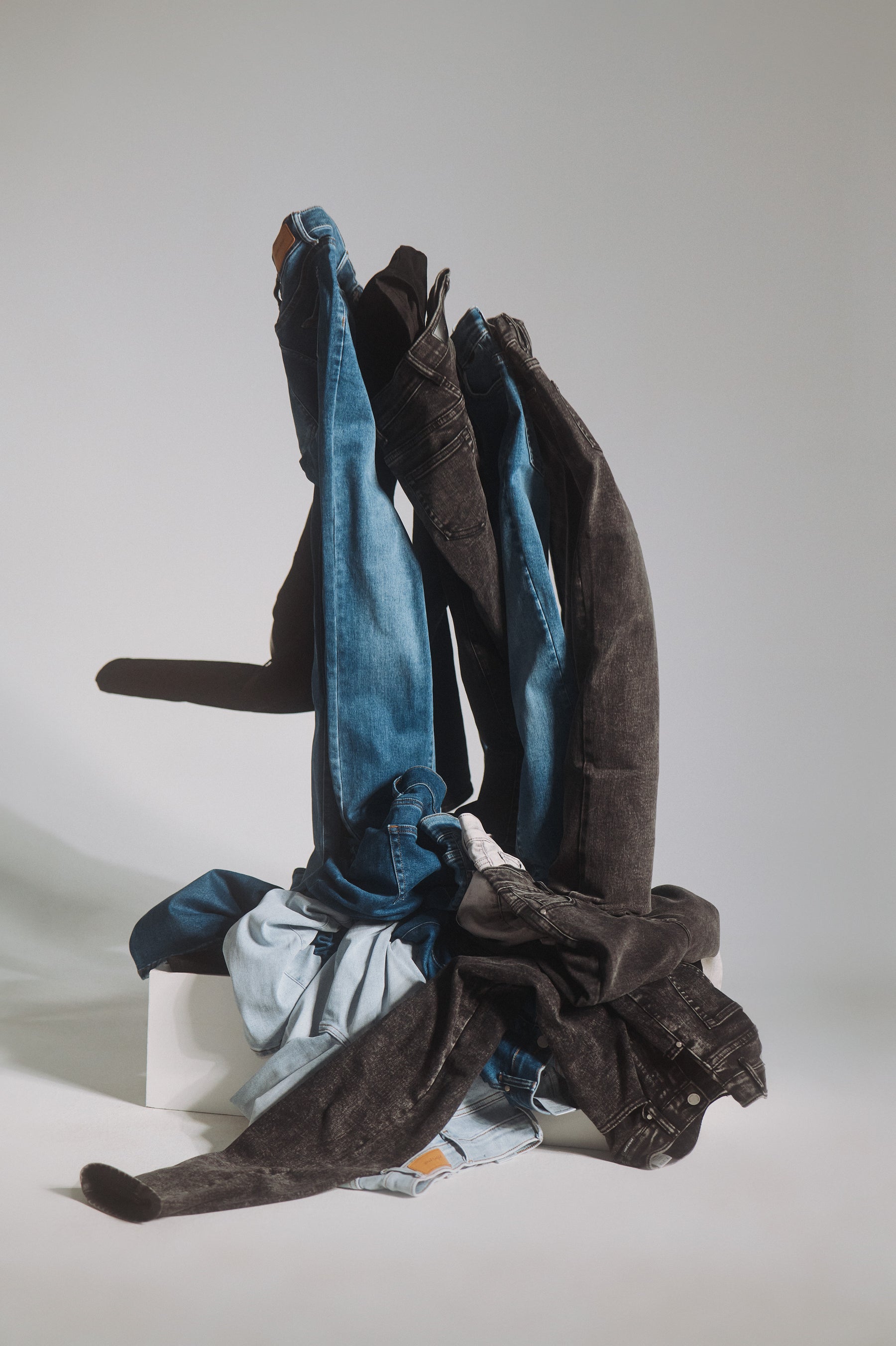 Forkskelligt farvede denim jeans fra Perfect Jeans, der bliver smidt i en bunke