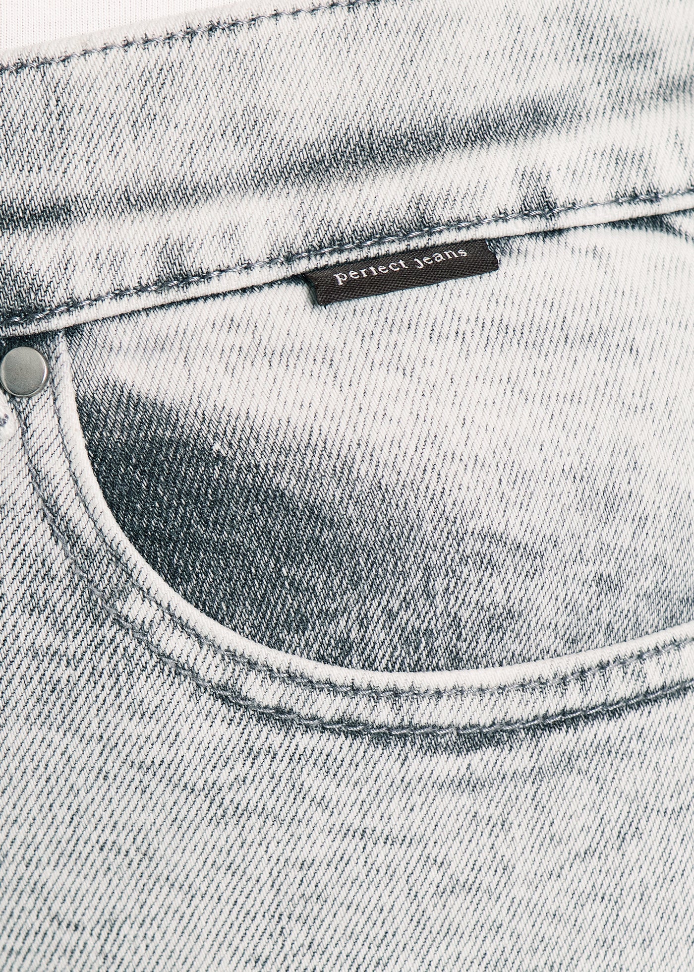 Forlommen på et par lysegrå denim jeans, hvor man kan se logoet.