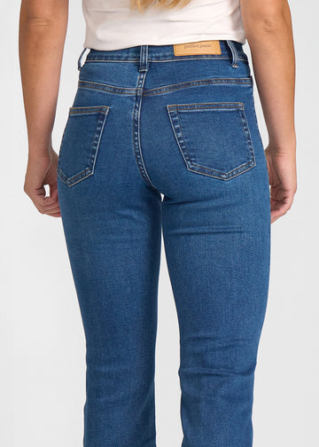 Mørkeblå denim bootcut jeans, modelnavn Oceans, som sidder tæt om hofter og lår med et let svaj fra knæet og ned, set bagfra tæt på for at vise detaljer..