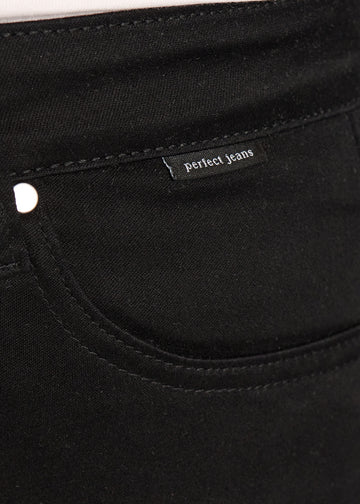 Forlommen på et par sort jeans, hvor man kan se logoet. på en plus-size model.