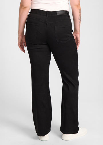 Sort bootcut jeans, modelnavn Ravens, som sidder tæt om hofter og lår med et let svaj fra knæet og ned, set bagfra, så man kan se hele produktet. på en plus-size model.