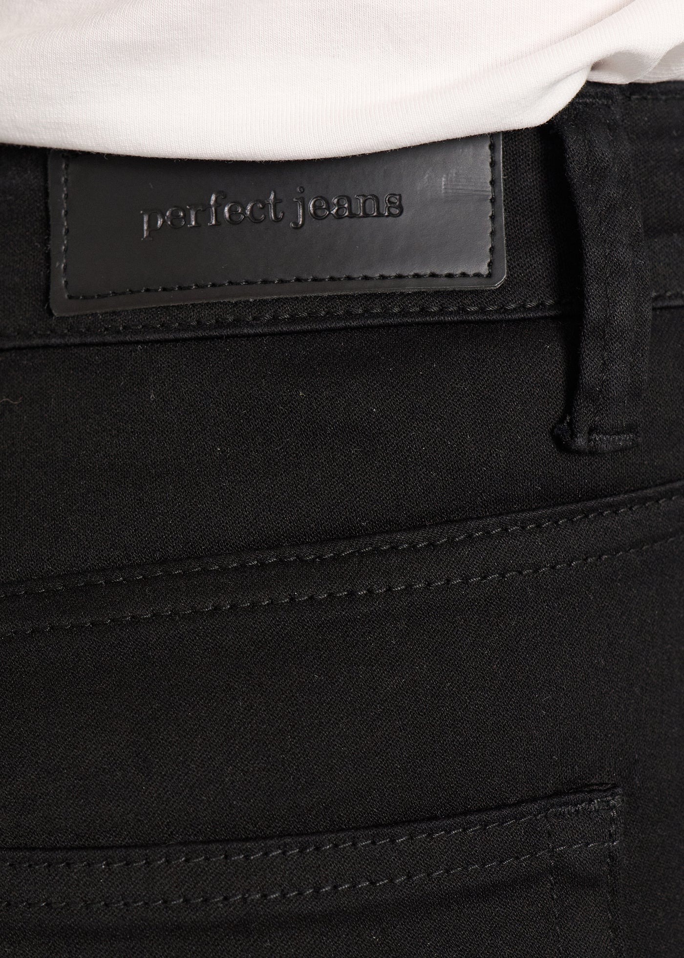 Baglommen på et par sort jeans, hvor man kan se logoet.