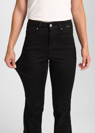 Model strækker jeansene ved låret for at vise stretch.