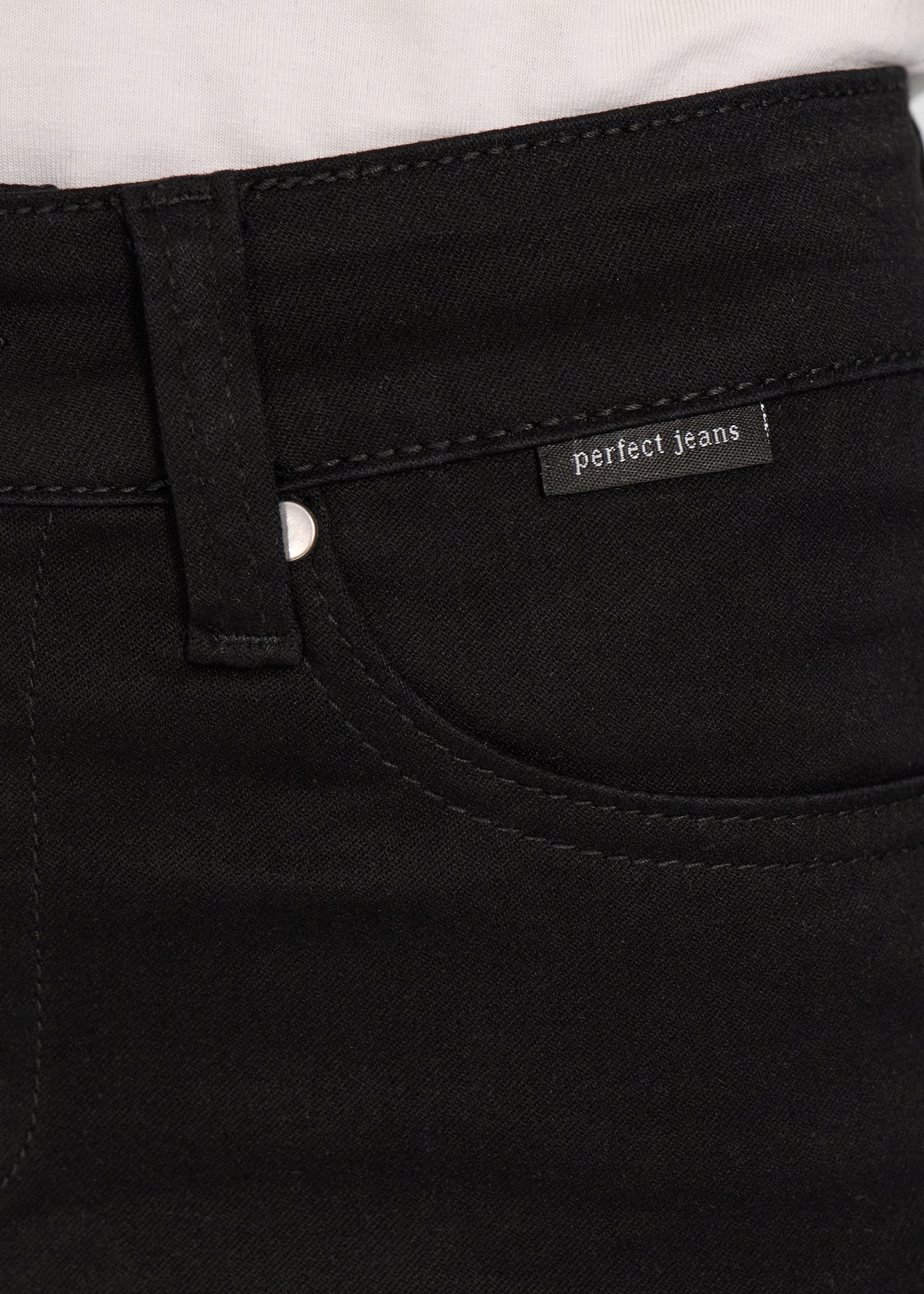 Forlommen på et par sort jeans, hvor man kan se logoet.