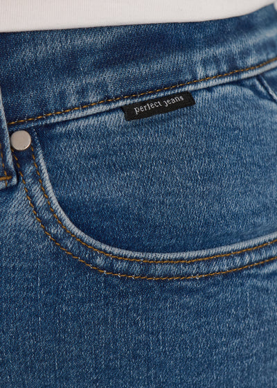 Forlommen på et par blå denim jeans, hvor man kan se logoet. på en plus-size model.