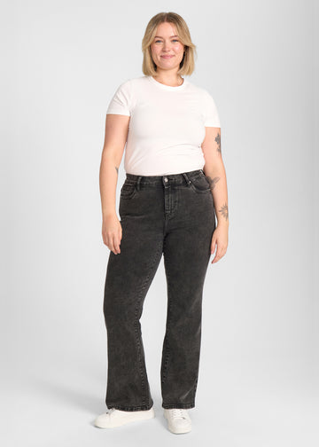 Fuldt billede af model i mørkegrå denim bootcut jeans på en plus-size model.