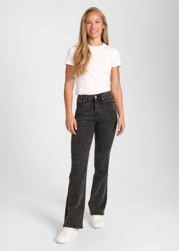 Fuldt billede af model i mørkegrå denim bootcut jeans.