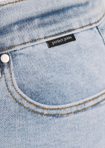 Forlommen på et par lyseblå denim jeans, hvor man kan se logoet. på en plus-size model.