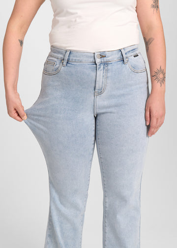 Model strækker jeansene ved låret for at vise stretch.