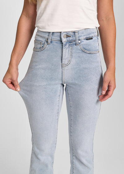 Model strækker jeansene ved låret for at vise stretch.