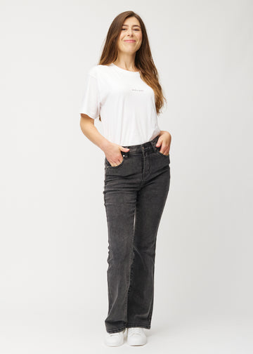Model går ind i billedet, strækker i jeansene, viser dem frem ved at dreje rundt og forlader derefter billedet.