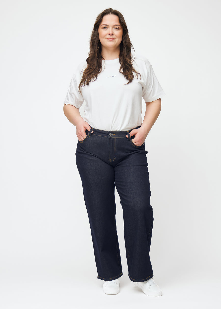 Plus-size model viser dyb mørkeblå denim jeans til kvinder i farven Midnights med loose pasform i bevægelse.