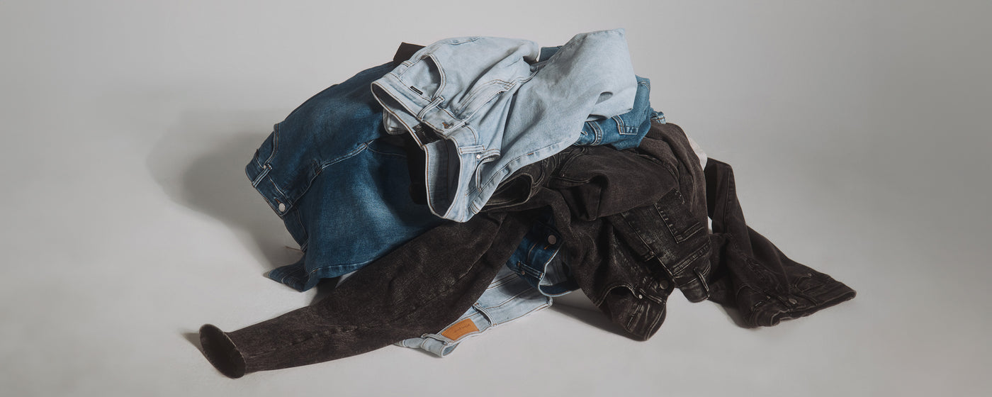 Forskelligt farvede denim jeans fra Perfect Jeans, som er blevet smidt i en bunke.